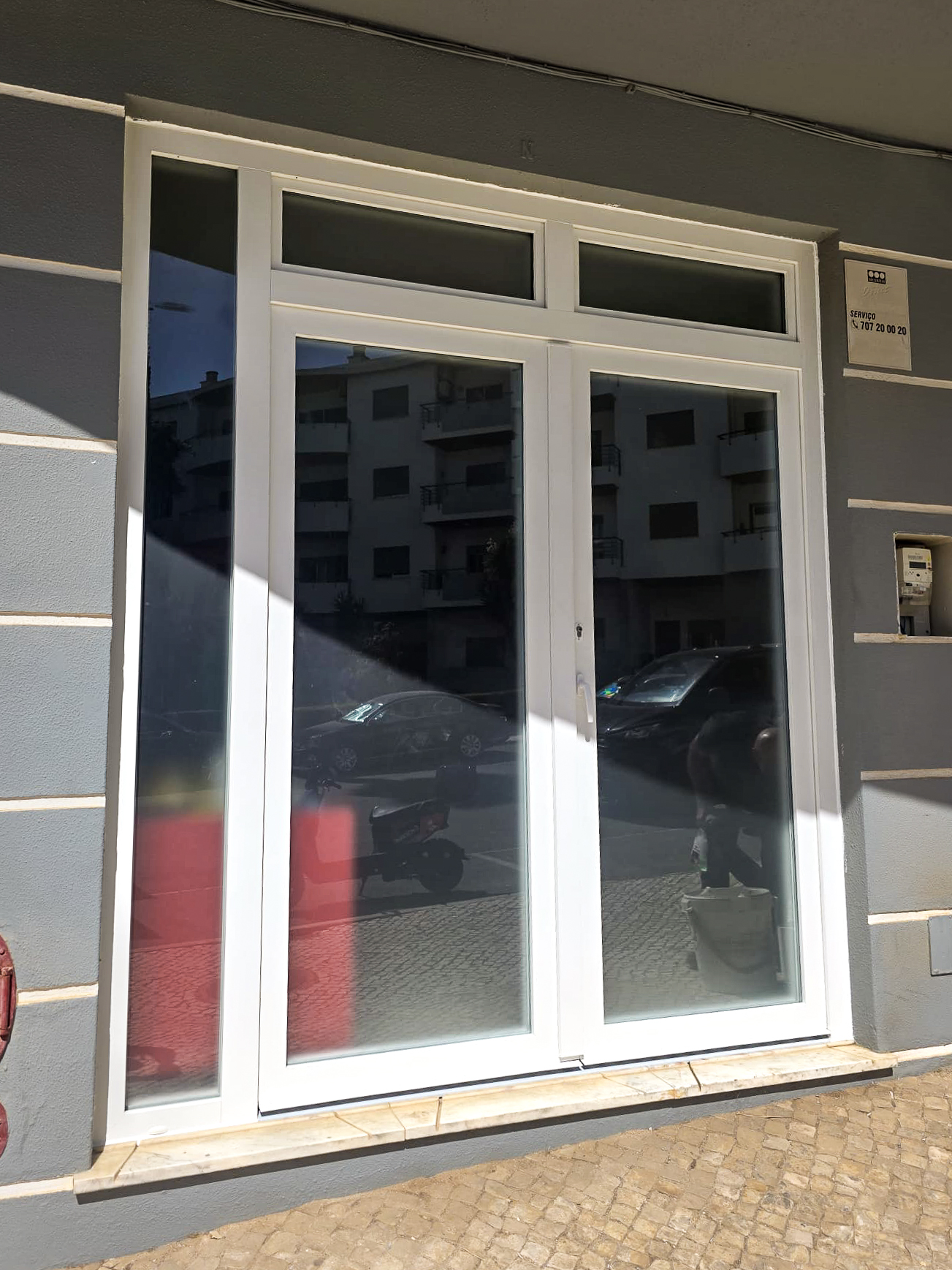 Porta de entrada com bandeira e fixo lateral, espaço comercial